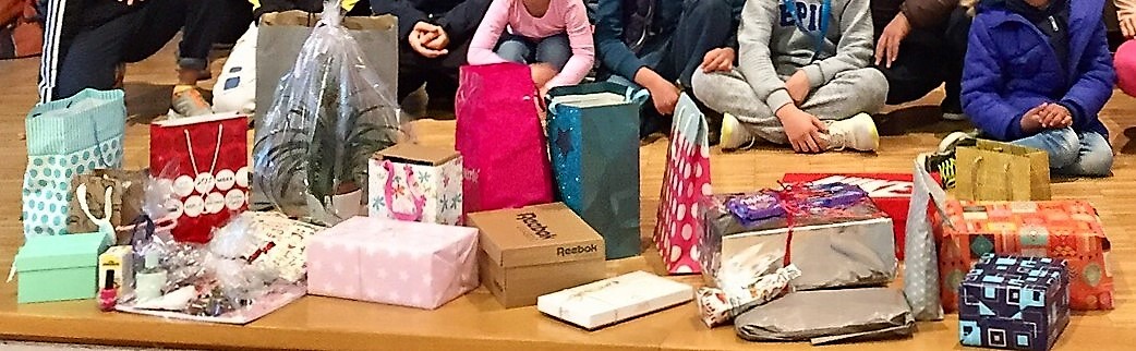 Geflüchtete Kinder mit den Geschenken, die SchülerInnen der Wessenberg-Schule im Vorfeld des Save me Treffs vorbereitet haben